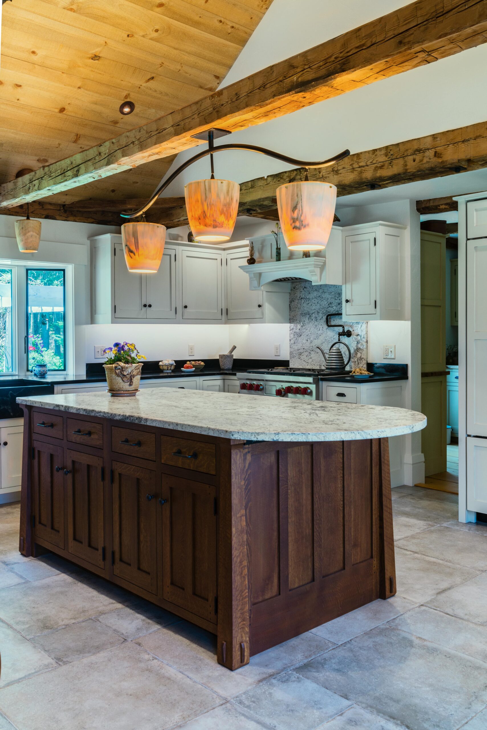 Large kitchen remodel with natural wood ceiling beams and granite island