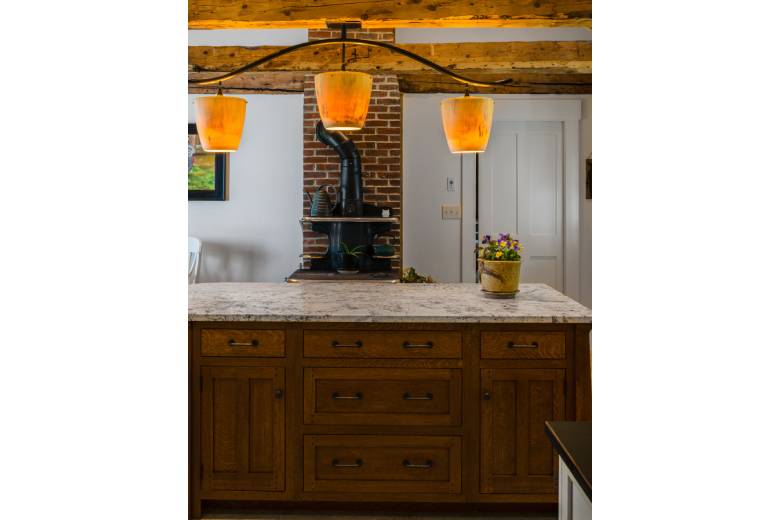 Island chandelier hanging from natural beams