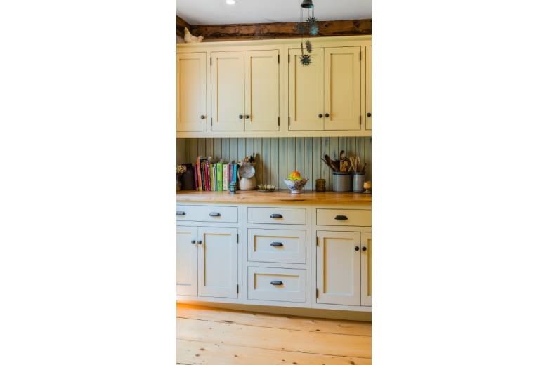 timber frame kitchen with white cabinets and wooden floors