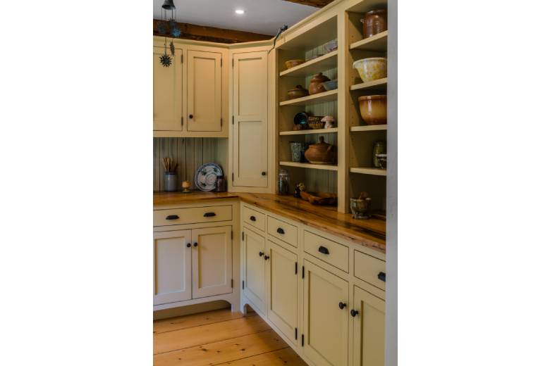 timber frame kitchen with wooden floors and white cabinets with open shelving
