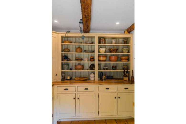 a kitchen with open shelving displaying bowls of many sizes and shapes