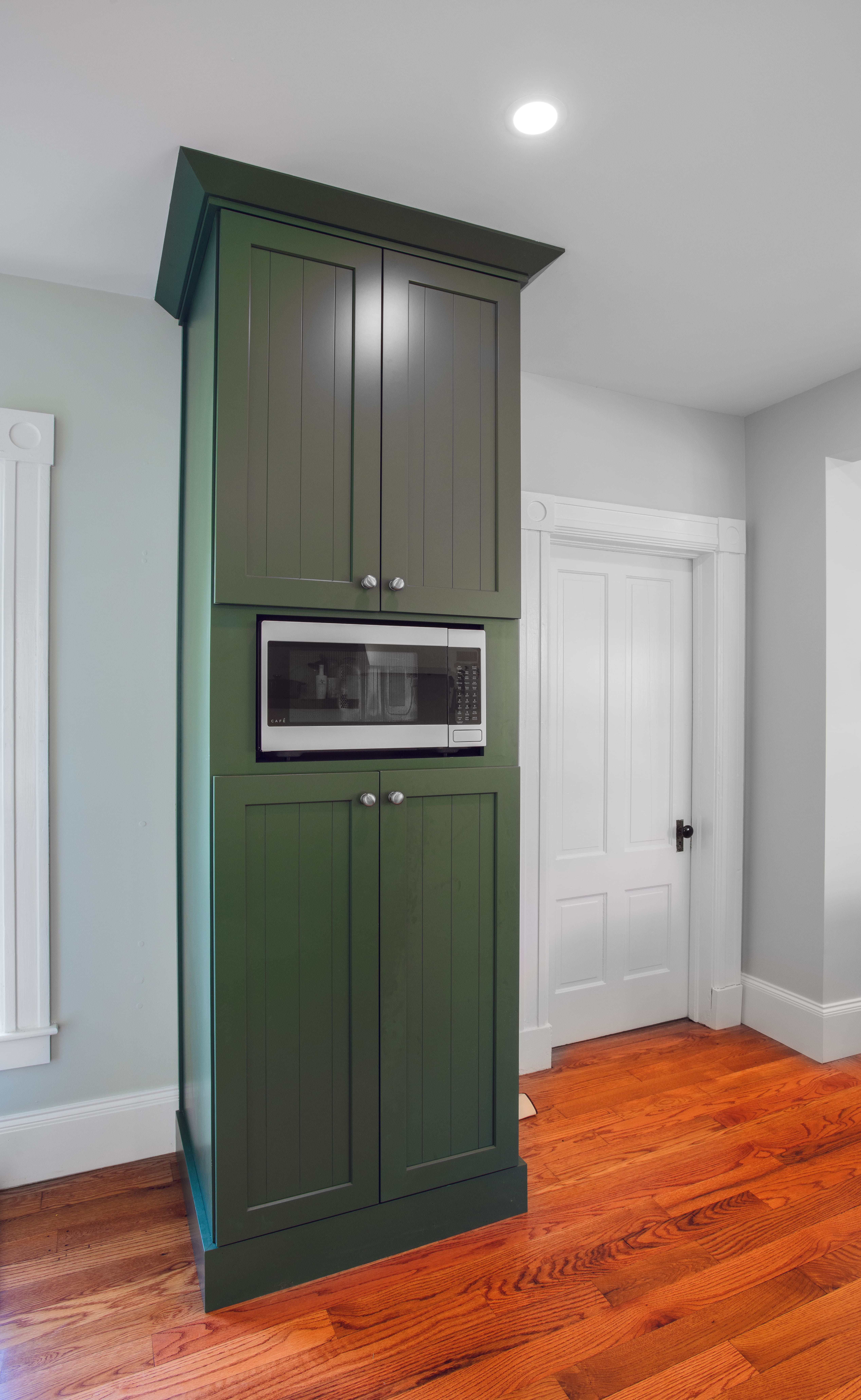 a green cabinet with a microwave built in