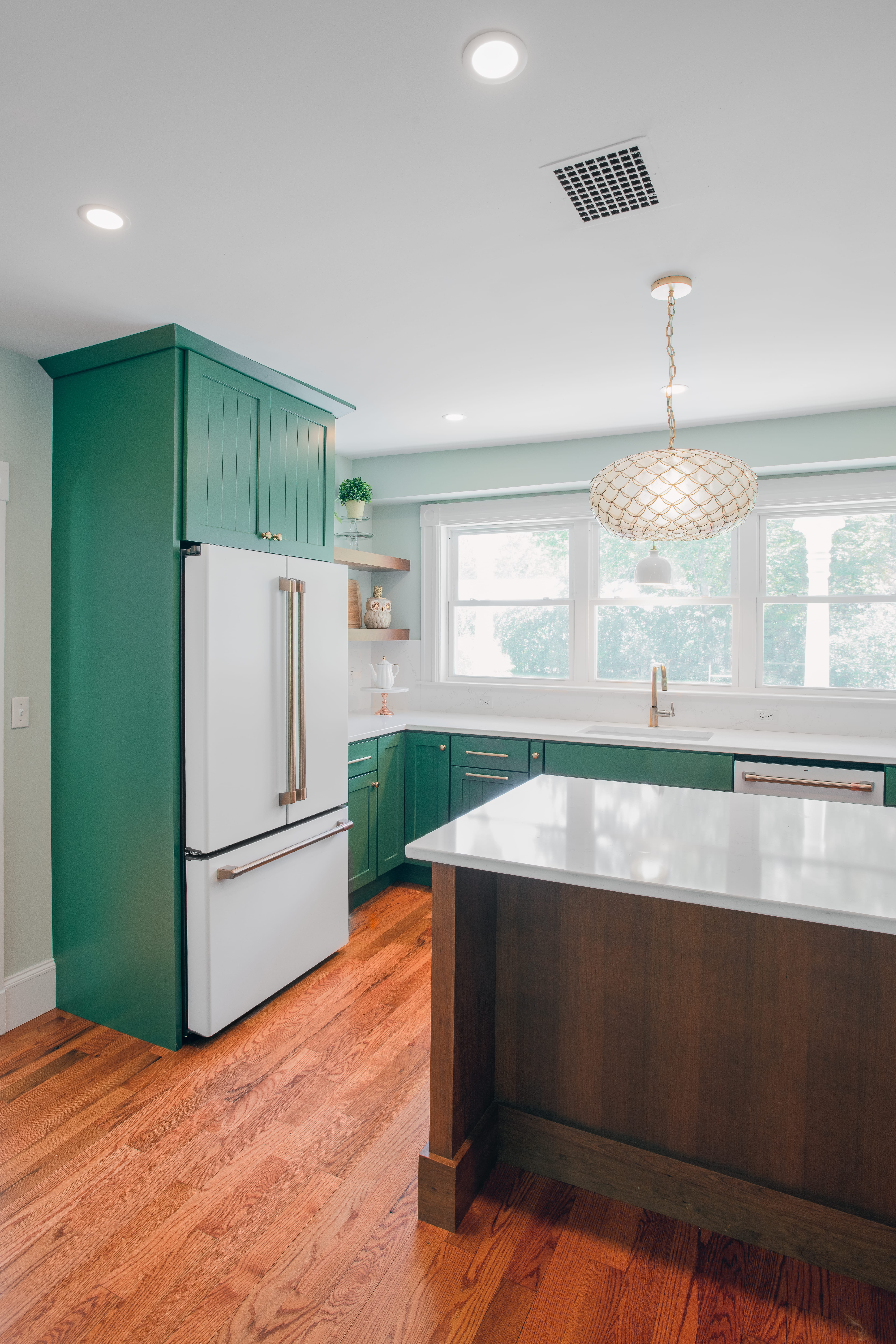 a kitchen with green cabinets and white appliances