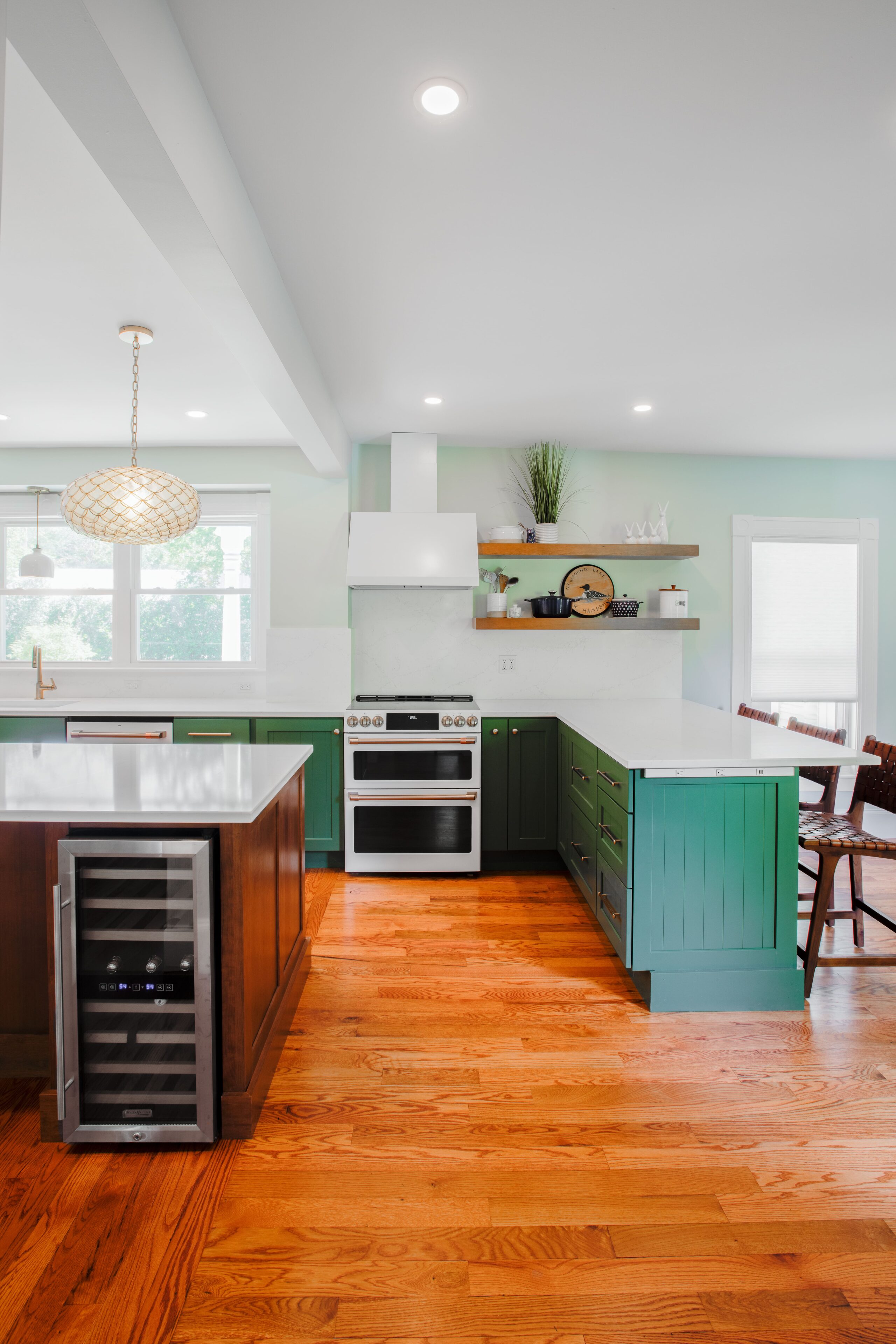 a kitchen with green cabinets and hardwood floors