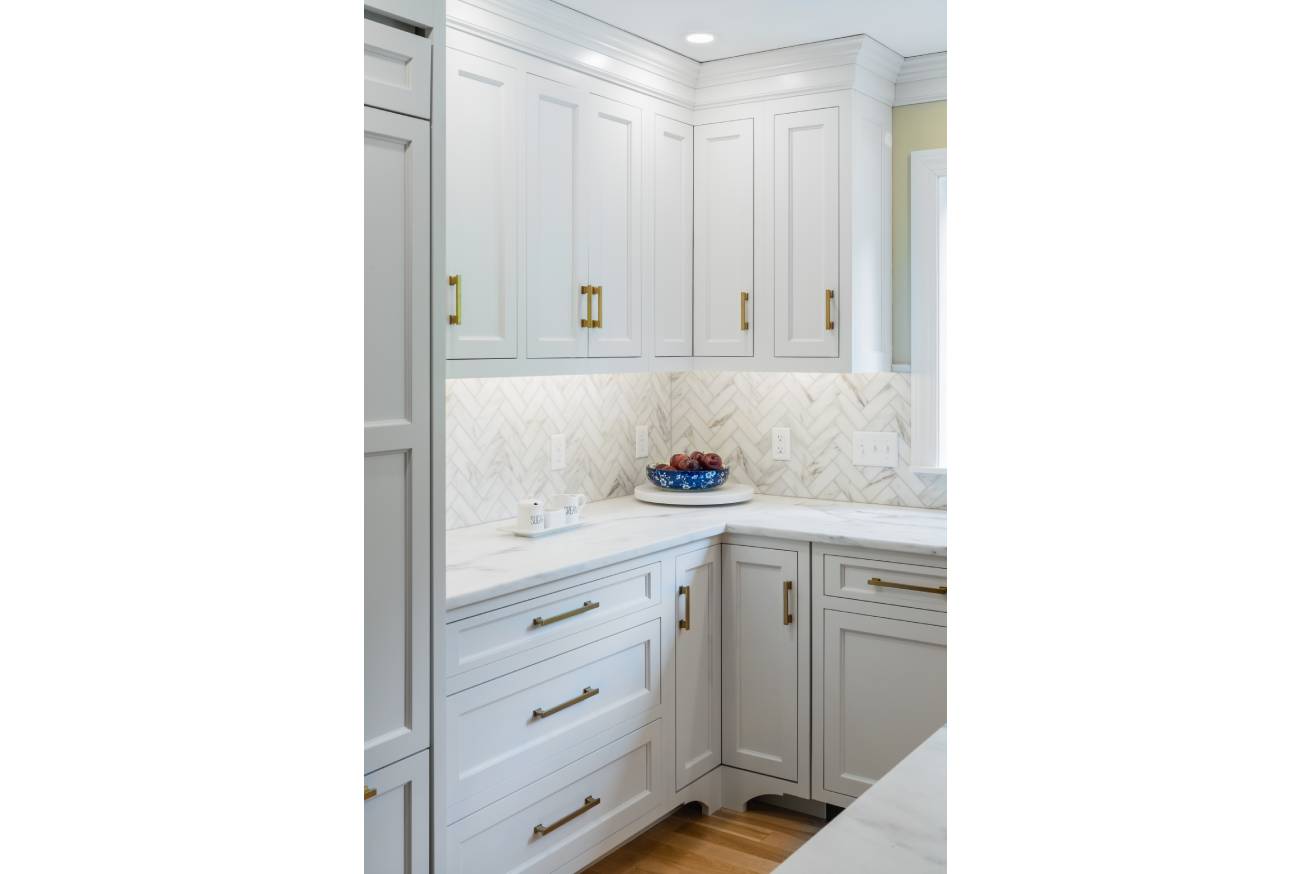 Gold brass handle son white cabinets with marble counters