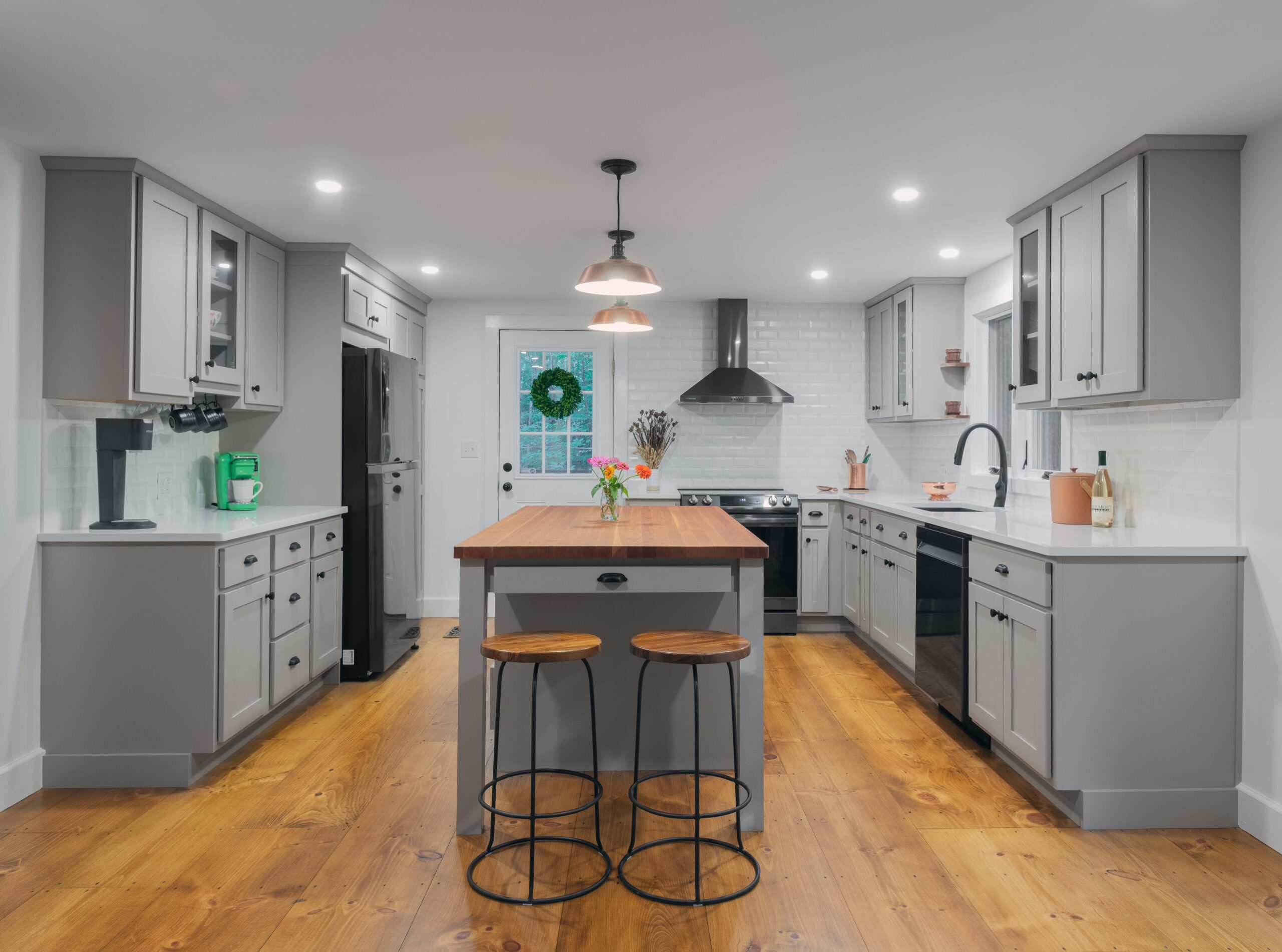 modern farmhouse style kitchen with two stools and a center island