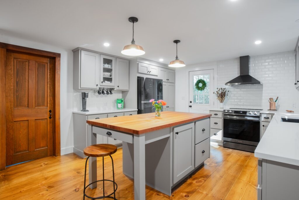 a large gray kitchen with a butcher block island in the middle