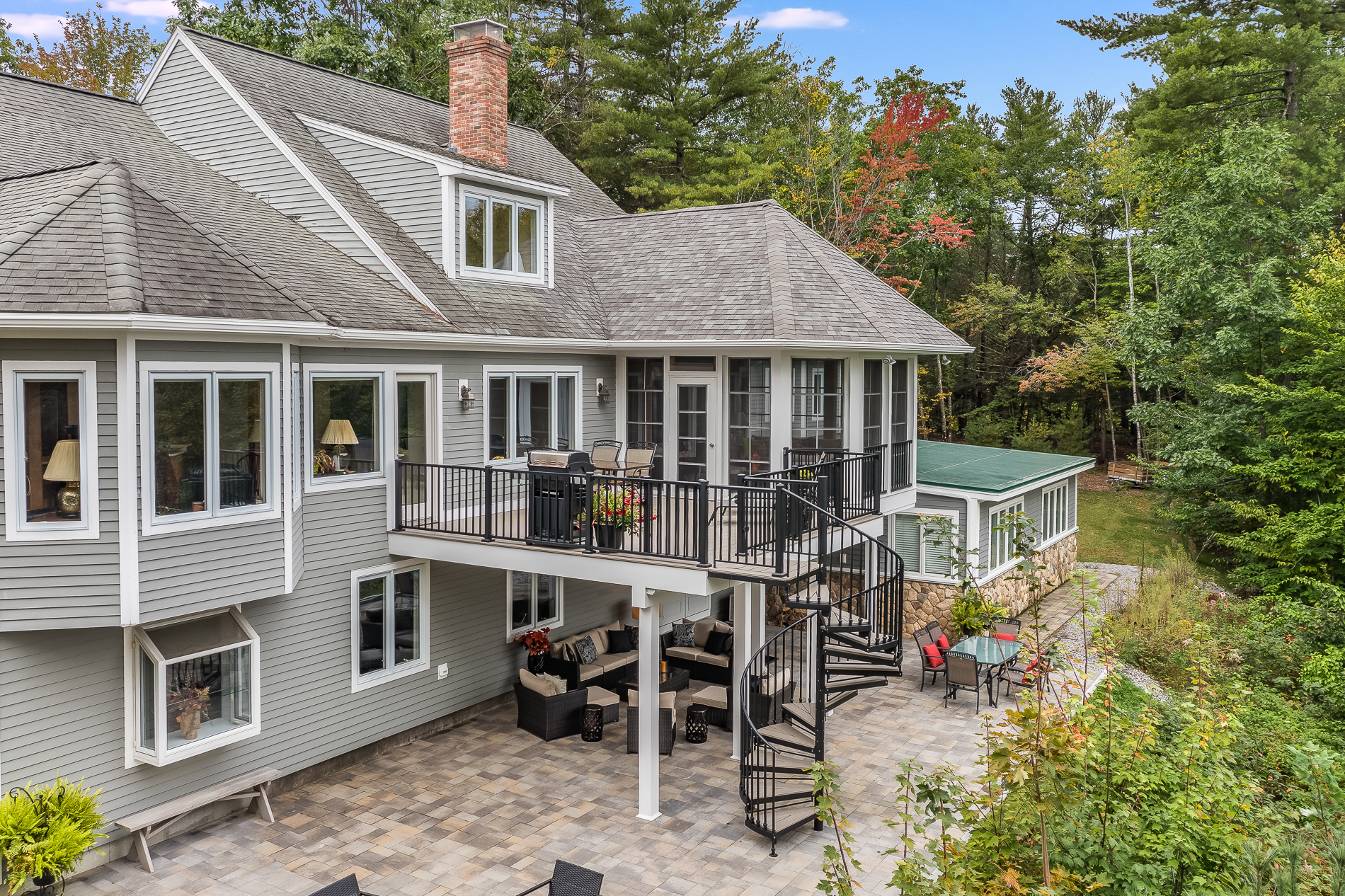 a large house with a deck and patio on the lower level