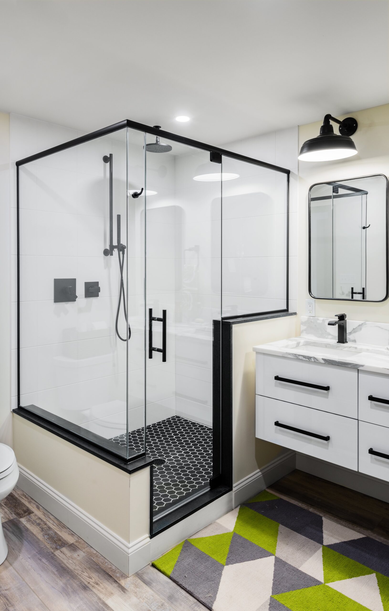 Modern bathroom remodel with black tile and glass shower door