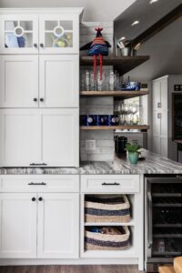a kitchen with white cabinets, open shelving, and marble counter tops