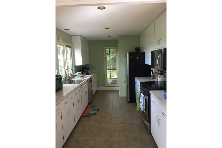 Small kitchen with old white cabinets and vinyl counters