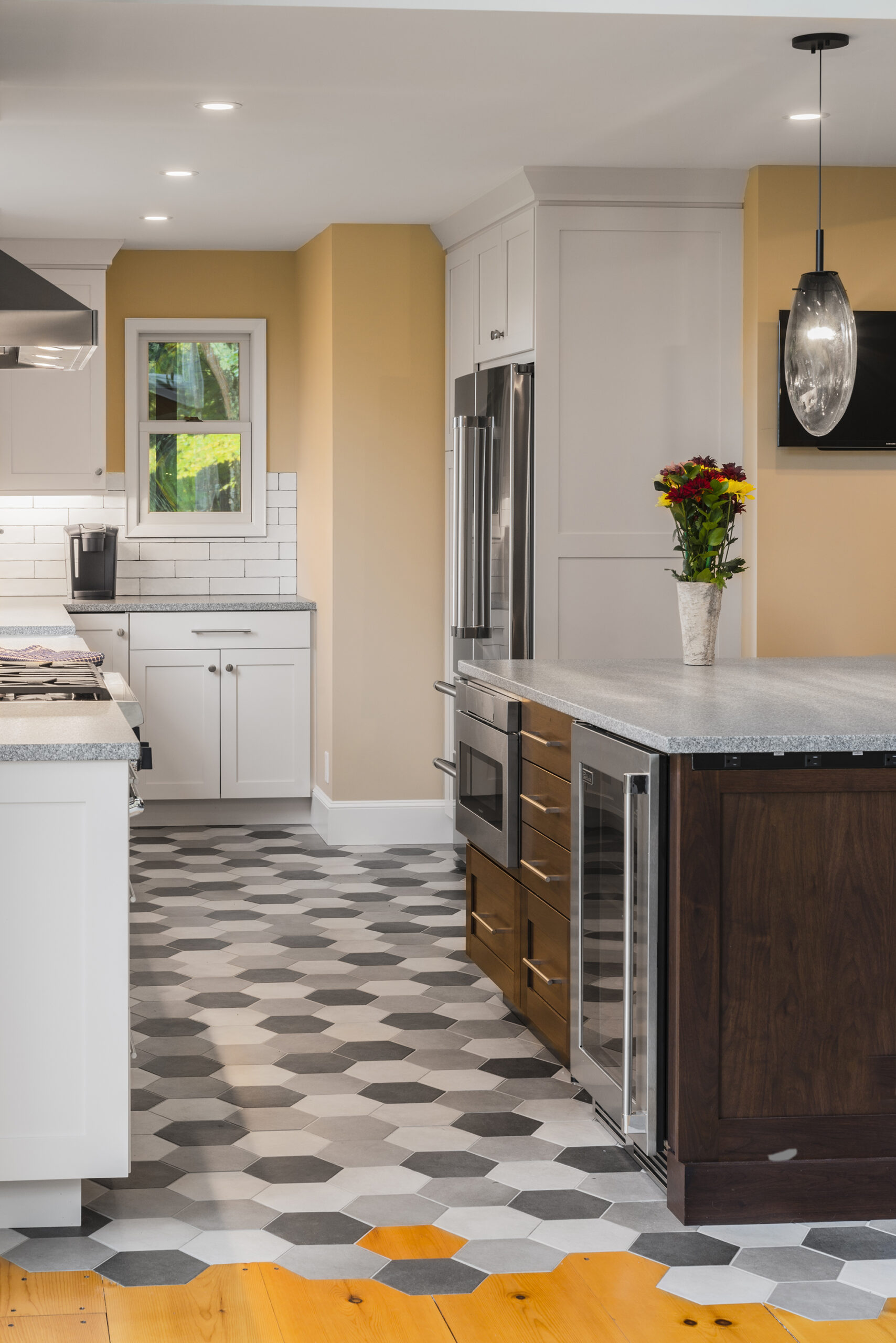 a kitchen with a wood center island, white cabinets, and honeycomb floor