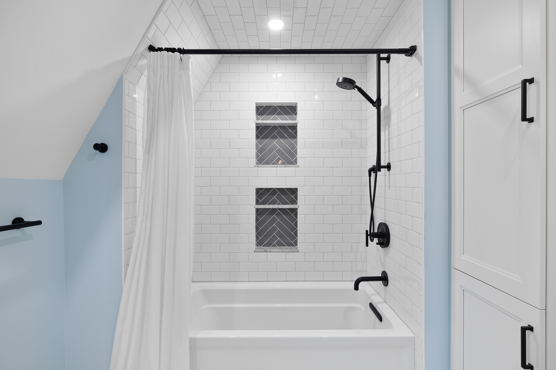 Modern Bathroom Shower with Subway Tile Backsplash and Black Accents
